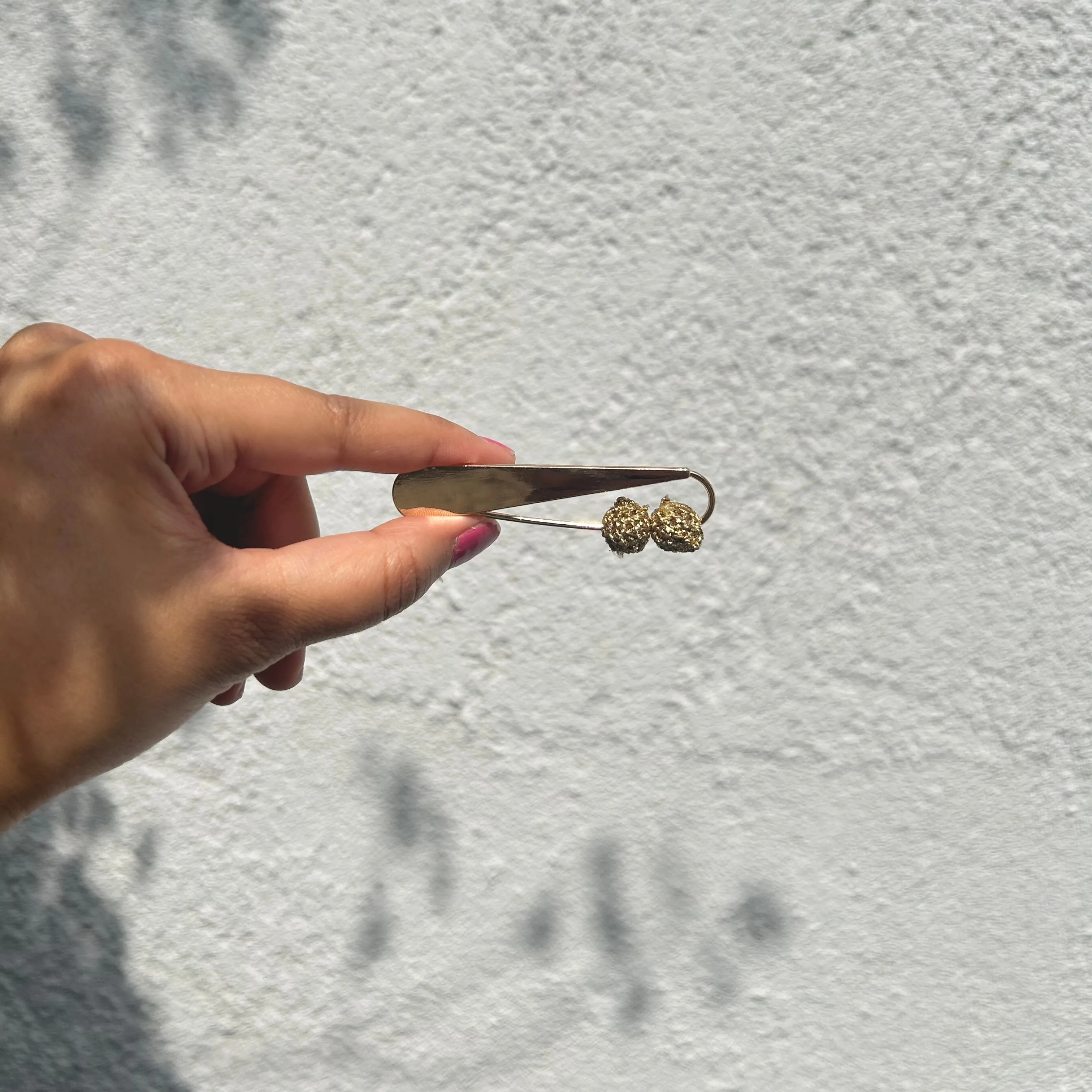 Golden crochet bead brooch on a metal pin
