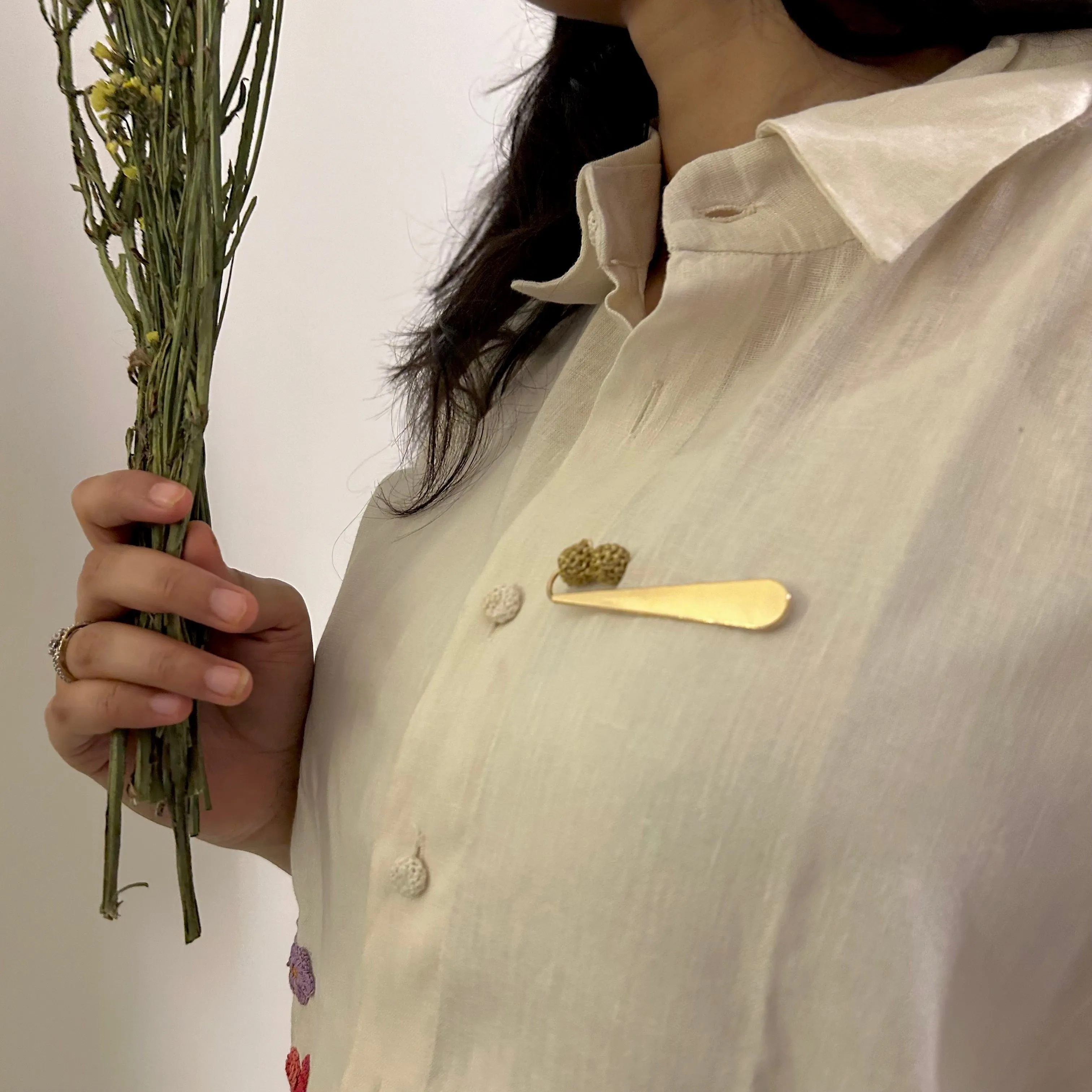 Golden crochet bead brooch on a metal pin